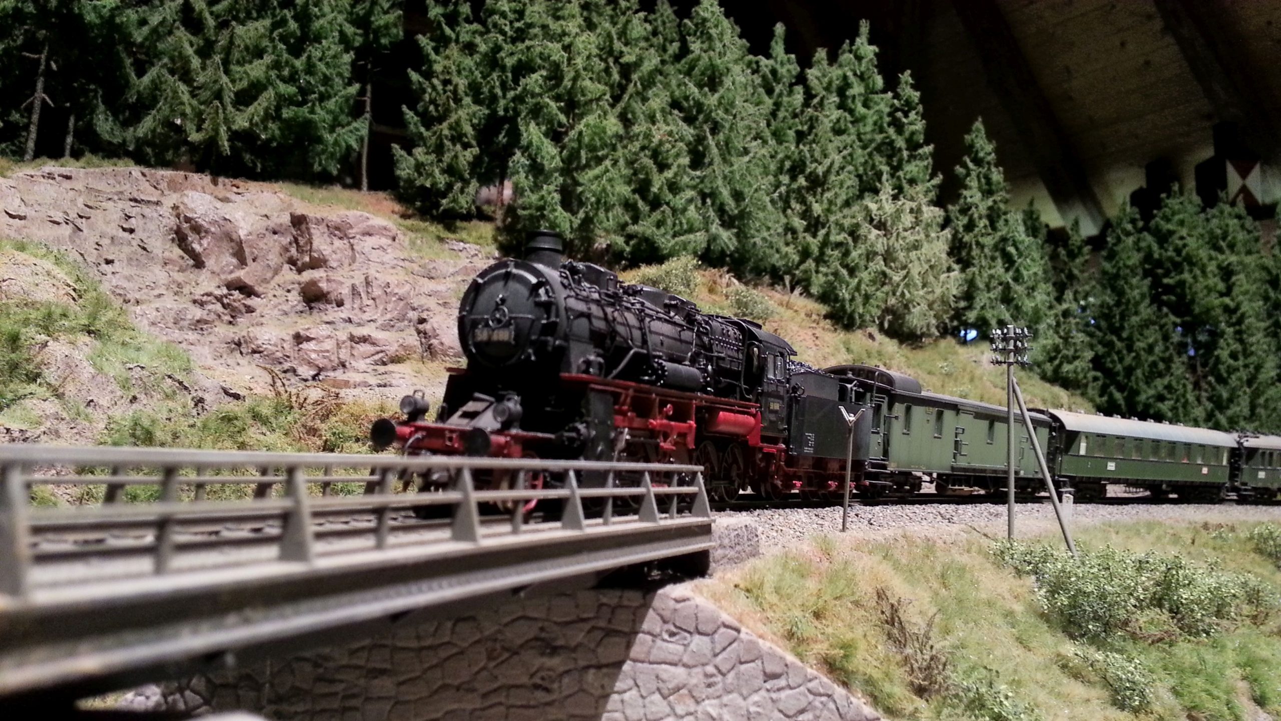 Foto der Modellbahnanlage: Lokomotive schiebt Güterwagen.