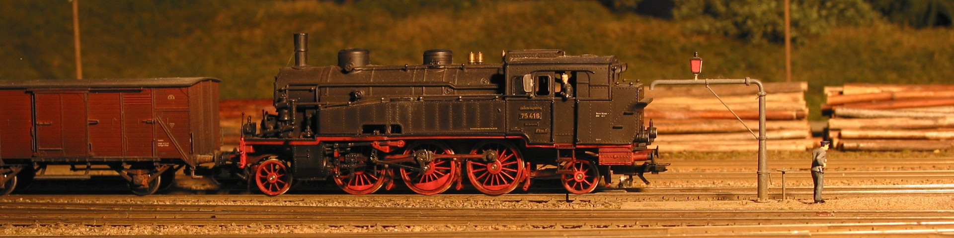 Foto der Modellbahnanlage: Lokomotive schiebt Güterwagen.